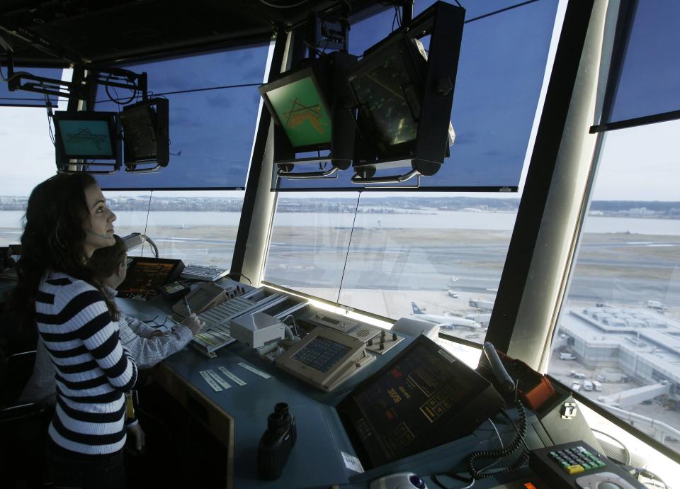 Reagan National Airport air traffic controller Sundie Yukich directs aircraft from the control tower in Washington in this file photo taken February 28, 2013. The U.S. air traffic control system is close to hitting a "yellow" alert level as people who keep radar and other equipment running remain out on furloughs due to the government shutdown, the head of the controllers union said on Thursday. (REUTERS/Gary Cameron)
