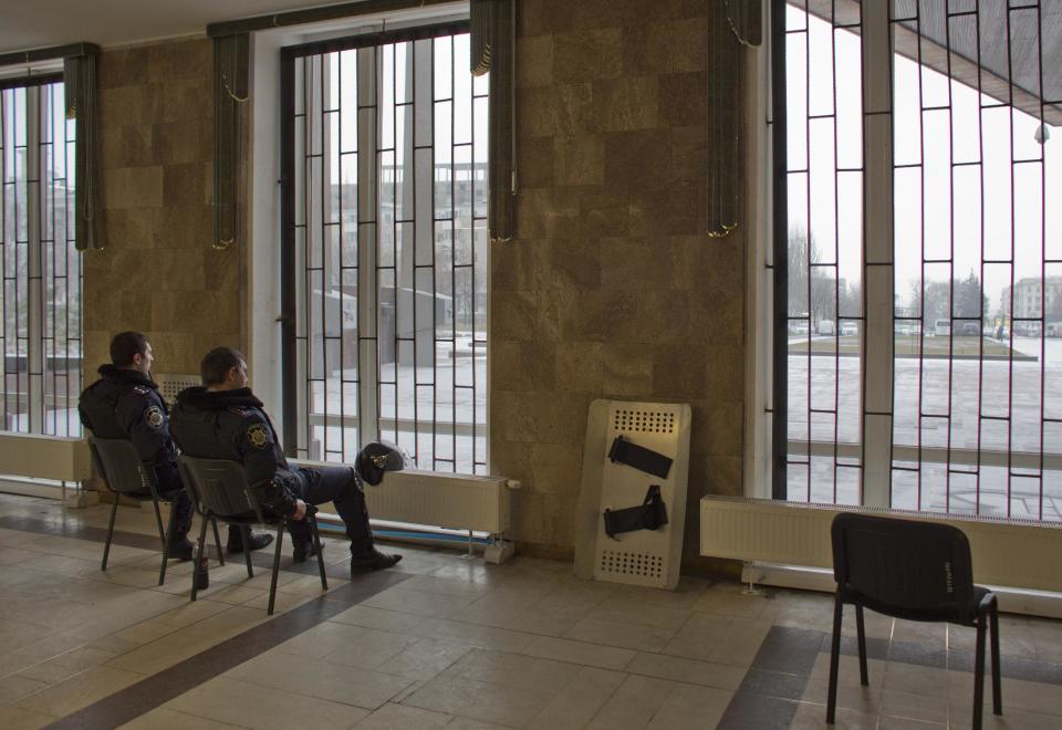 In this photo taken Wednesday, Feb. 26, 2014, police officer secure a local government building in Donetsk, eastern Ukraine. If Ukraine looks neatly delineated on maps, its history is a tangle of invasions and occupations and peoples and religions, a place of ill-defined borders that for centuries has been struggling to define itself. The modern nation is so sharply divided by culture and loyalty, split between allegiance to Moscow and allegiance to Western Europe, that it often can appear ready to simply snap in two. (AP Photo/Darko Bandic)