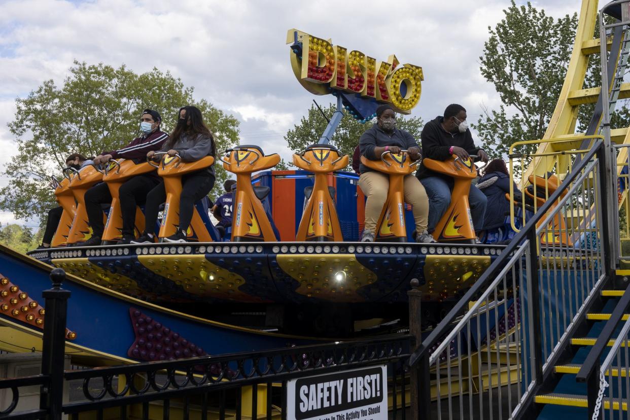 Portland, OR, USA - Apr 25, 2021: Masked visitors to Portland's Oaks Amusement Park that reopens in compliance with COVID mandates during a pandemic springtime.