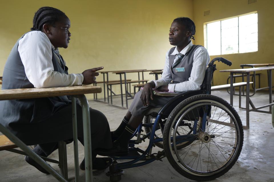 Bridget Chanda, left, chats to her friend Juliet Nankamba at the Chileshe Chepela Special School in Kasama, Zambia, Wednesday, March 6, 2024. (AP Photo/Tsvangirayi Mukwazhi)