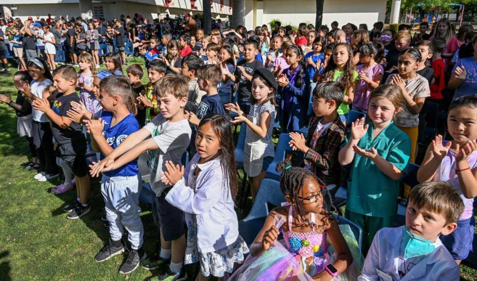 Red Bank Elementary school students stand and cheer for Sharon Lamb, a Clovis Unified teacher for 50 years and current Red Bank kindergarten teacher, as she is honored with a special dedication in the school’s yearbook during a surprise presentation on Friday, June 2, 2023.