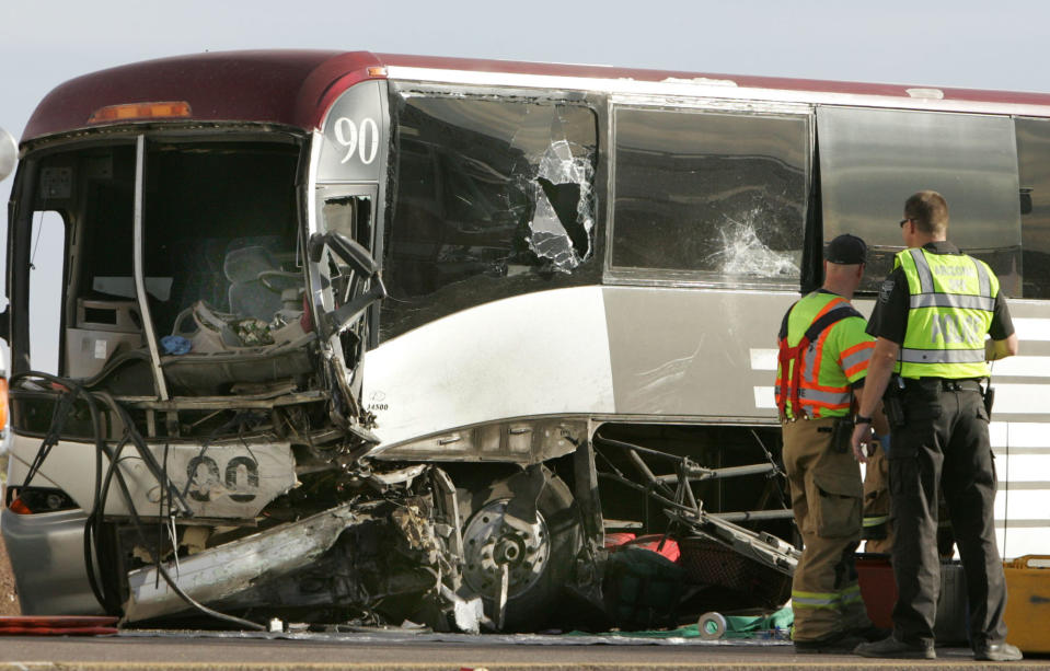 Emergency personnel survey the damage to a tour bus that was struck by a pickup truck traveling east in the the westbound lanes of Interstate, Tuesday, Nov. 20, 2012 in Casa Grande, Ariz. The driver of the truck was killed, two people were flown to Phoenix hospitals and six were transported to Casa Grande Regional Medical Center. The collision is under investigation by Arizona Department of Public Safety Highway Patrol. (AP Photo/Casa Grande Dispatch, Oscar Perez)