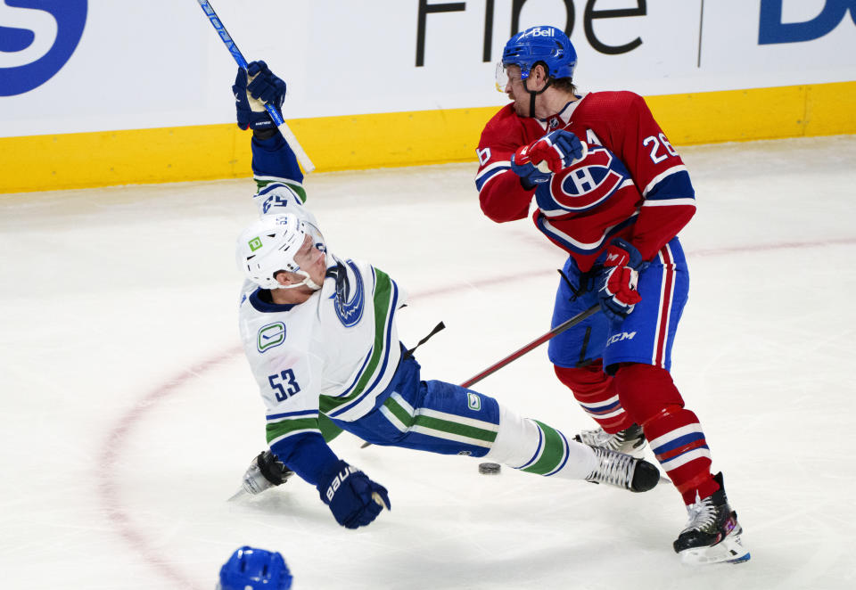 Vancouver Canucks' Bo Horvat (53) is topped by Montreal Canadiens defenseman Jeff Petry during the first period of an NHL hockey game, Monday, Nov. 29, 2021 in Montreal. (Paul Chiasson/The Canadian Press via AP)