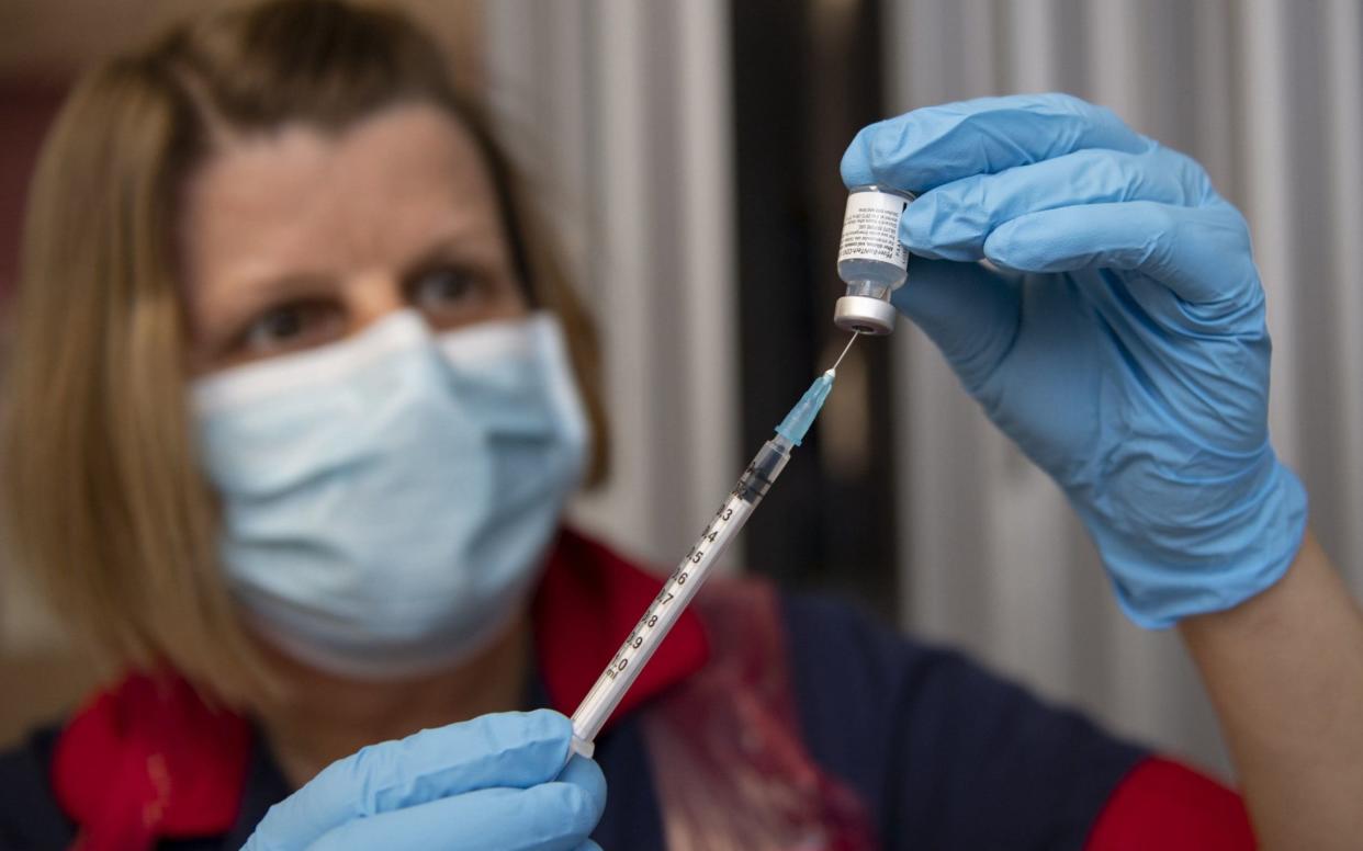 A nurse filling a syringe with a Covid-19 vaccine. Unions representing more than 1.3 million health workers are urging the Prime Minister to speed up the pay process to show he cares about staff facing "burnout" because of the strain of dealing with the coronavirus crisis -  Andy Stenning/PA