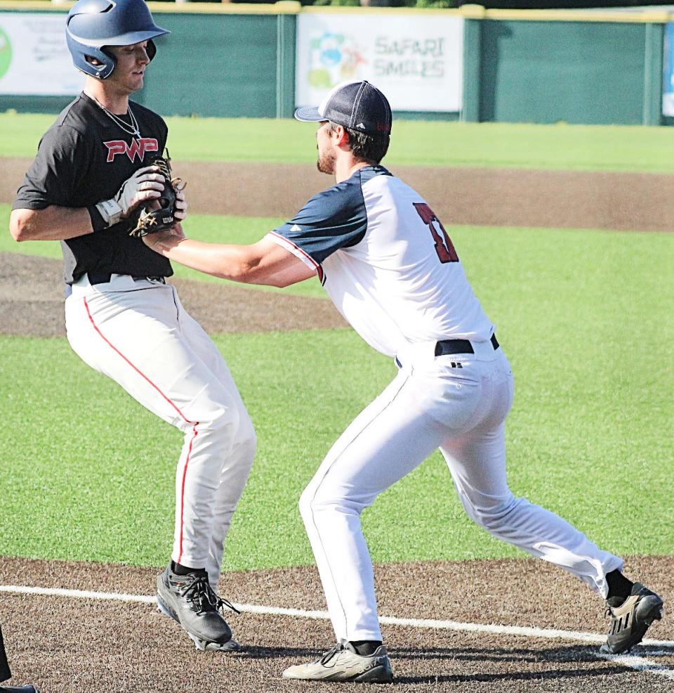 Bartlesville Doenges Ford Indians pitcher Josh Weber, right, waits to administer a tag near home plate during last Wednesday's 2-2 tie against the Jenks-based Marucci Midwest team.