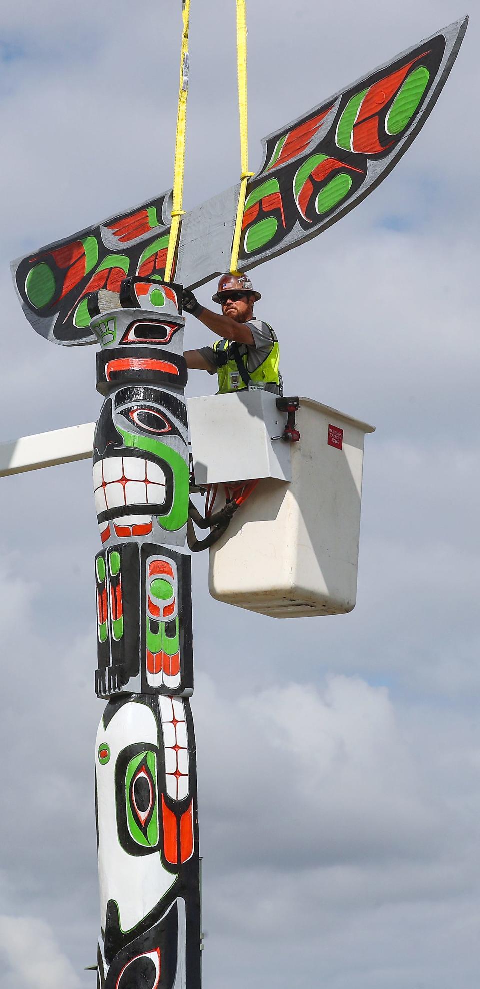 Port Orchard Public Works’s Tom Lovely guides the wings of the totem pole into position as a crew reinstalls the newly restored totem pole at the end of Sidney Ave. on the waterfront on Wednesday, Aug. 30, 2023.