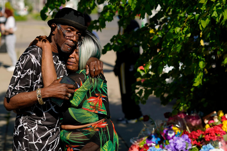 FILE - People embrace outside the scene of a shooting at a supermarket a day earlier, in Buffalo, N.Y., Sunday, May 15, 2022. The shooting is the latest example of something that's been part of U.S. history since the beginning: targeted racial violence. The Buffalo Bills have been a reliable bright spot for a city that has been shaken by a racist mass shooting and back-to-back snowstorms in recent months. So when Bills safety Damar Hamlin was critically hurt in a game Monday, the city quickly looked for ways to support the team. (AP Photo/Matt Rourke, File)