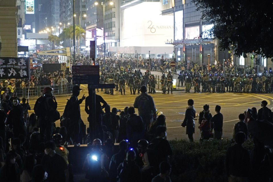 Riot police gather as they confront protesters during a rally on Christmas Eve in Hong Kong, Tuesday, Dec. 24, 2019. More than six months of protests have beset the city with frequent confrontations between protesters and police. (AP Photo/Kin Cheung)