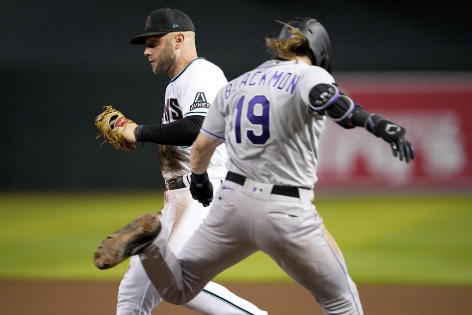 Arizona Diamondbacks' Christian Walker beats Colorado Rockies' Charlie Blackmon (19) to the bag for the out during the sixth inning of a baseball game, Tuesday, Sept. 5, 2023, in Phoenix. (AP Photo/Matt York)