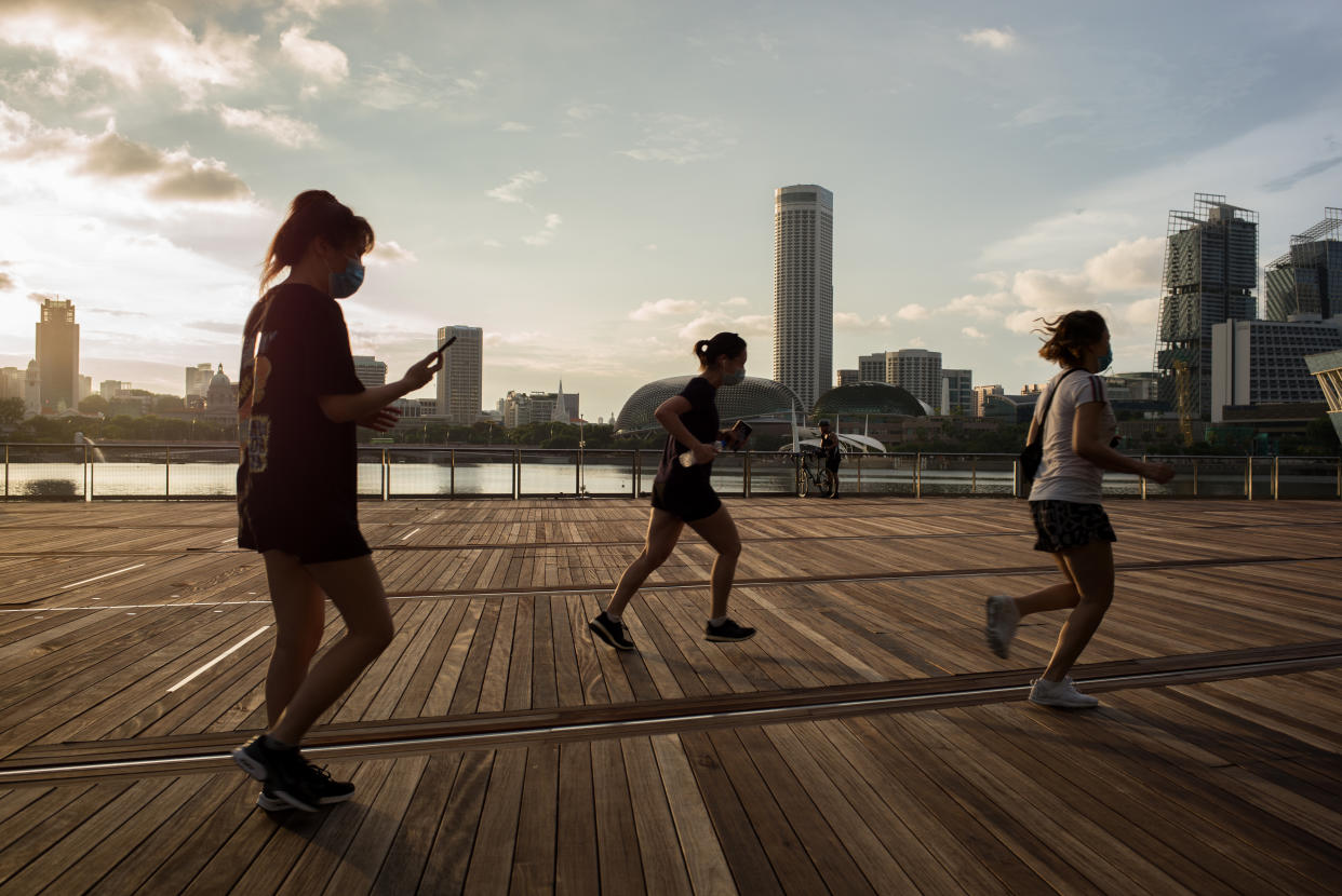 SINGAPORE - 2020/05/16: People wearing face mask as a preventive measure jog outside Marina Bay Sands during the Coronavirus (COVID-19) crisis. Singapore has so far confirmed 27,356 coronavirus cases, 22 deaths and 8,342 recovered, based on the latest update by the country's Ministry of Health. (Photo by Maverick Asio/SOPA Images/LightRocket via Getty Images)