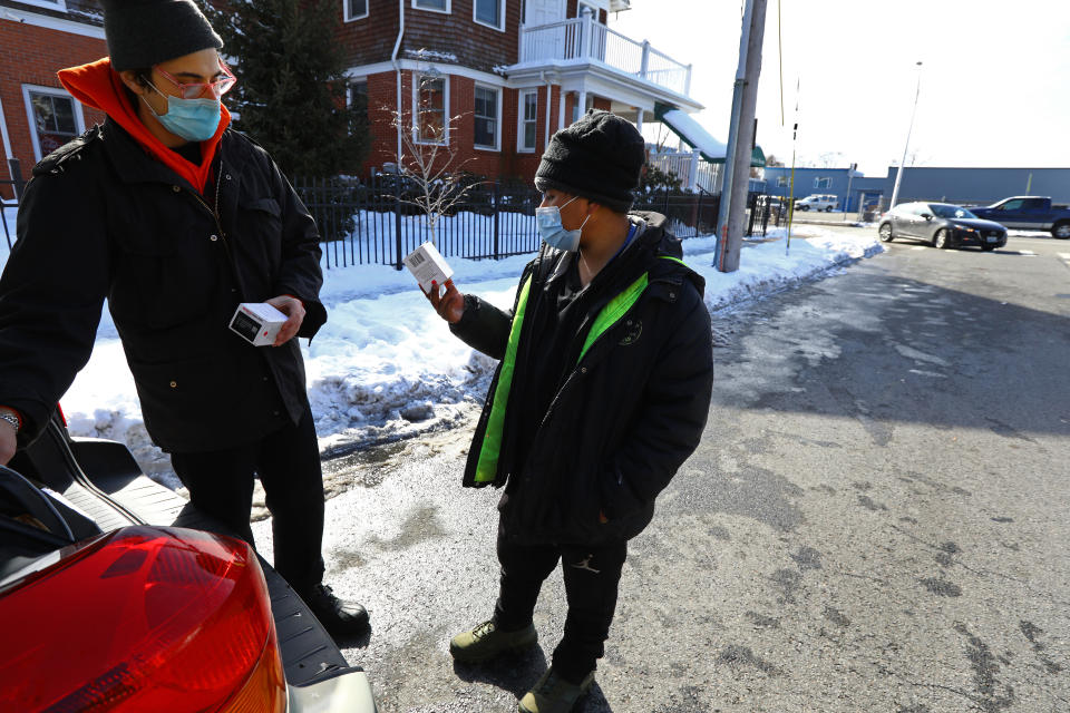 PROVIDENCE - FEBRUARY 11: Diego Arene-Morley, left, a peer-recovery specialist with RICARES (Rhode Island Communities for Addiction Recovery Efforts), talks to Cesar Gomez about Narcan nasal spray in Providence, RI on Feb. 11, 2021. Gomez said he's saved someone's life using Narcan. Rhode Island had a record level of accidental drug overdose deaths in 2020. (Photo by Pat Greenhouse/The Boston Globe via Getty Images)