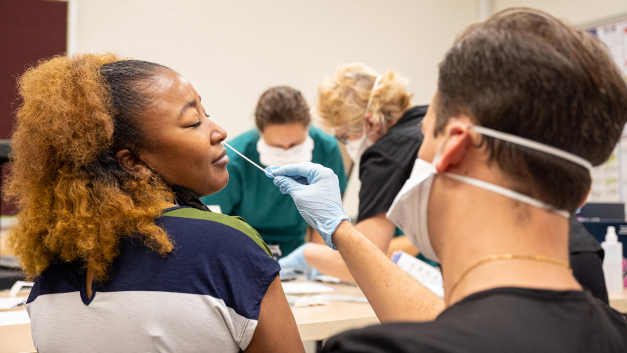 Lashaun Pettigrew, a school bookkeeper, has her nose swabbed by a nurse during a COVID-19 test at Brandeis Elementary School in Louisville, Ky.