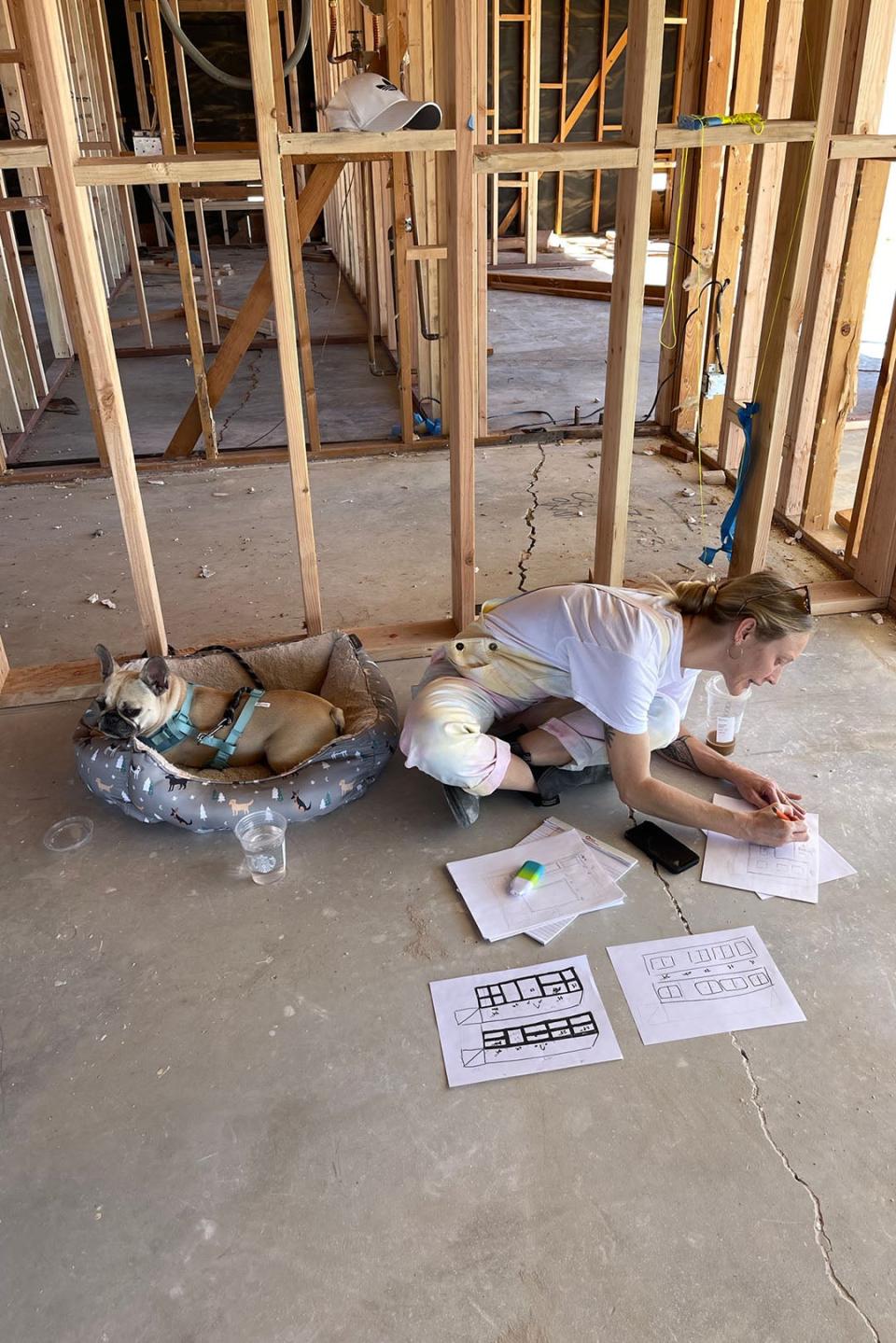 woman on floor drawing up plans