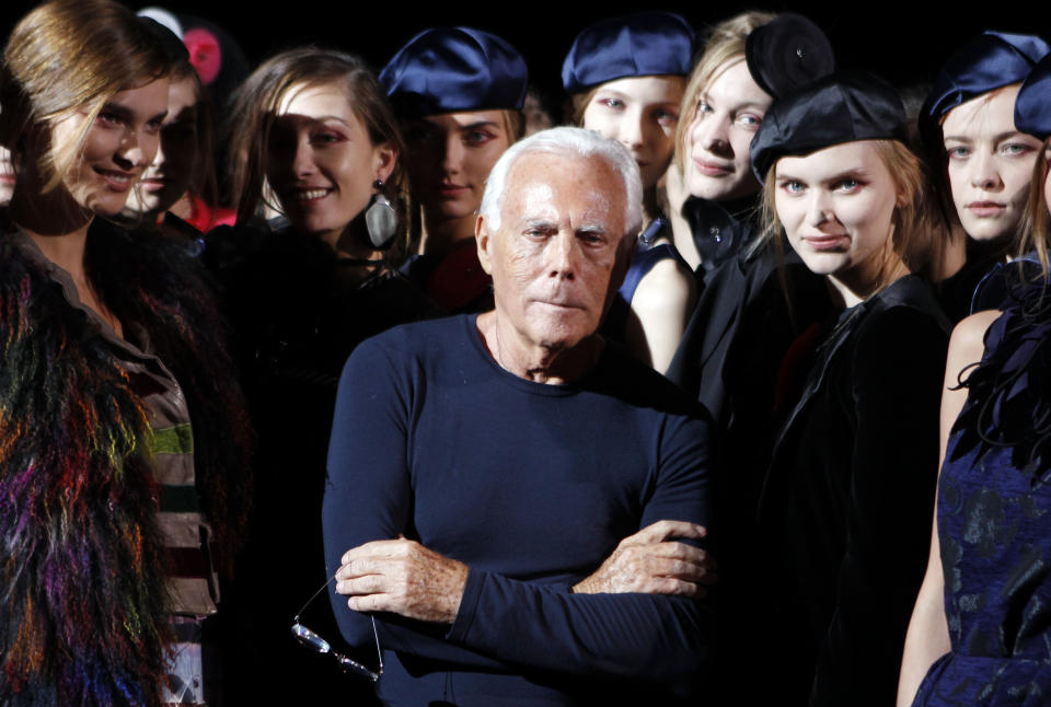 Italian fashion designer Giorgio Armani poses with models at the end of the Emporio Armani women's Fall-Winter 2012-2013 collection that was presented in Milan, Italy, Saturday, Feb. 25, 2012.(AP Photo/Luca Bruno)