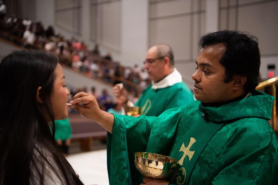 Father Shinto Padinjaredathu gives communion to a congregation member at Iglesia Sagrado Corazon de Jesus in Nashville, Tenn., Sunday, July 14, 2024. Padinjaredathu is a visiting pastor from St. Henry Catholic Church.