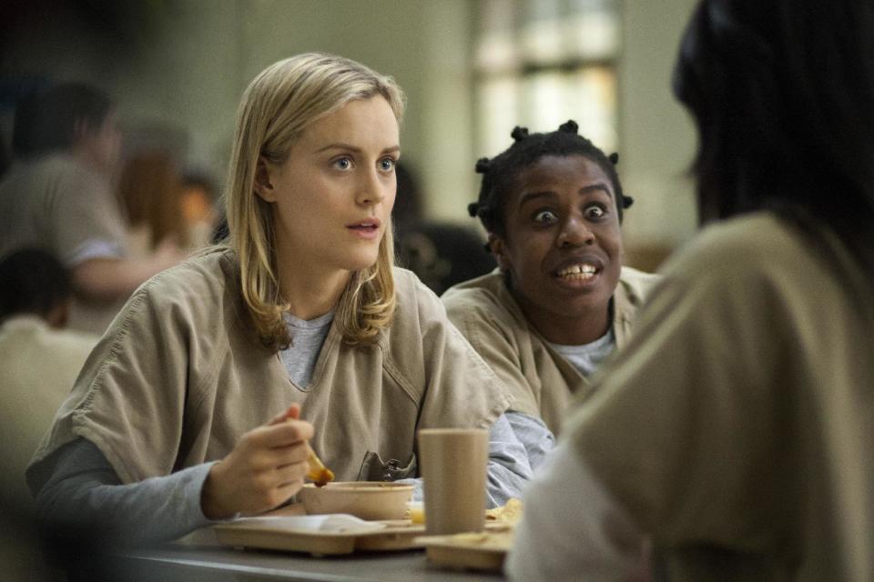 FILE - This image released by Netflix shows Taylor Schilling, left, and Uzo Aduba in a scene from "Orange Is the New Black." Season two debuts on Netflix on June 6, 2014. (AP Photo/Netflix, Paul Schiraldi, file)