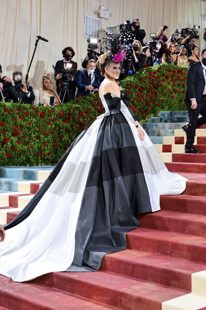 Sarah Jessica Parker in a plaid gown with a long train and a feathery hat