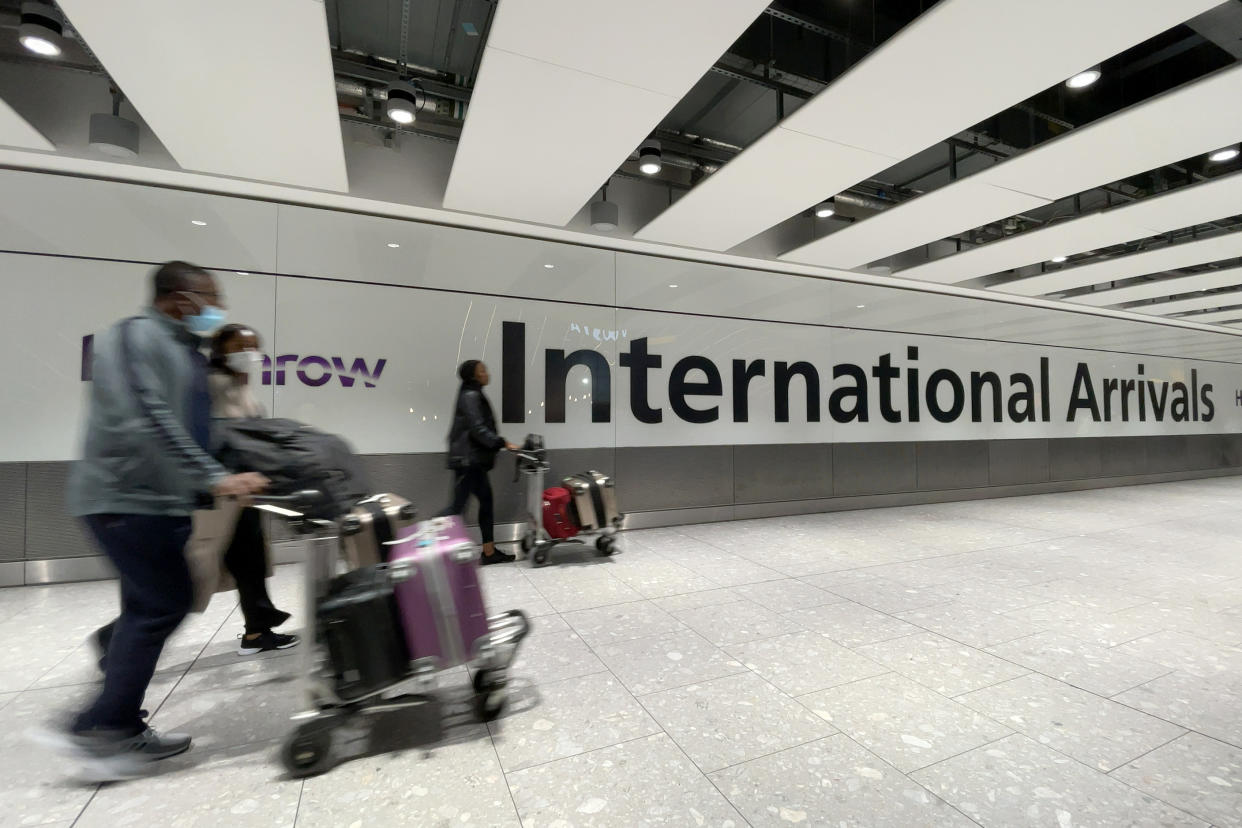 LONDON, ENGLAND - NOVEMBER 26: International passengers walk through the arrivals area at Terminal 5 at Heathrow Airport on November 26, 2021 in London, England. A heavily-mutated new variant of the Covid-19 virus, currently called B.1.1.529, has been detected in South Africa, Botswana and Hong Kong. The U.K. Health Secretary Sajid Javid said from 12:00 GMT on Friday all flights from South Africa, Namibia, Zimbabwe, Botswana, Lesotho and Eswatini are being suspended and the countries added to the UK's travel Red List. (Photo by Leon Neal/Getty Images)