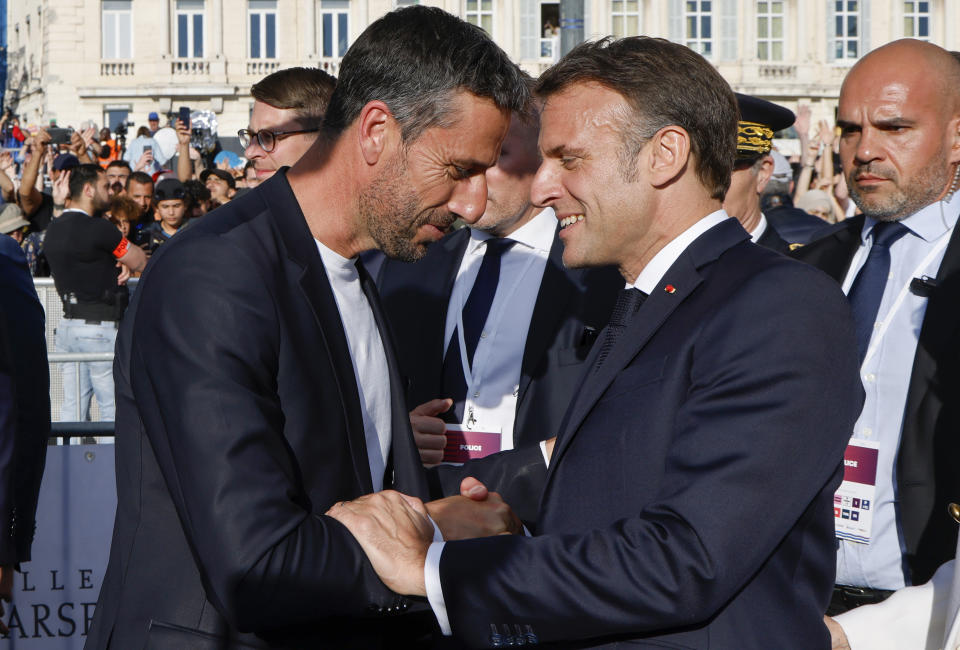 President of the Paris 2024 Olympics and Paralympics Organizing Committee Tony Estanguet, left, shakes hands French President Emmanuel Macron during the Olympic torch arrival ceremony in Marseille, southern France, Wednesday May 8, 2024. The Olympic flame arrived in Marseille's Old Port Wednesday on a majestic three-mast ship from Greece for the welcoming ceremony at sunset in the city's Old Port. (Ludovic Marin, Pool via AP)
