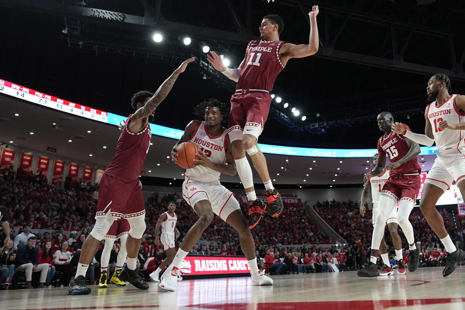 Houston's Tramon Mark (12) is fouled by Temple's Nick Jourdain (11) as Damian Dunn (1) helps defend during the first half of an NCAA college basketball game Sunday, Jan. 22, 2023, in Houston. (AP Photo/David J. Phillip)