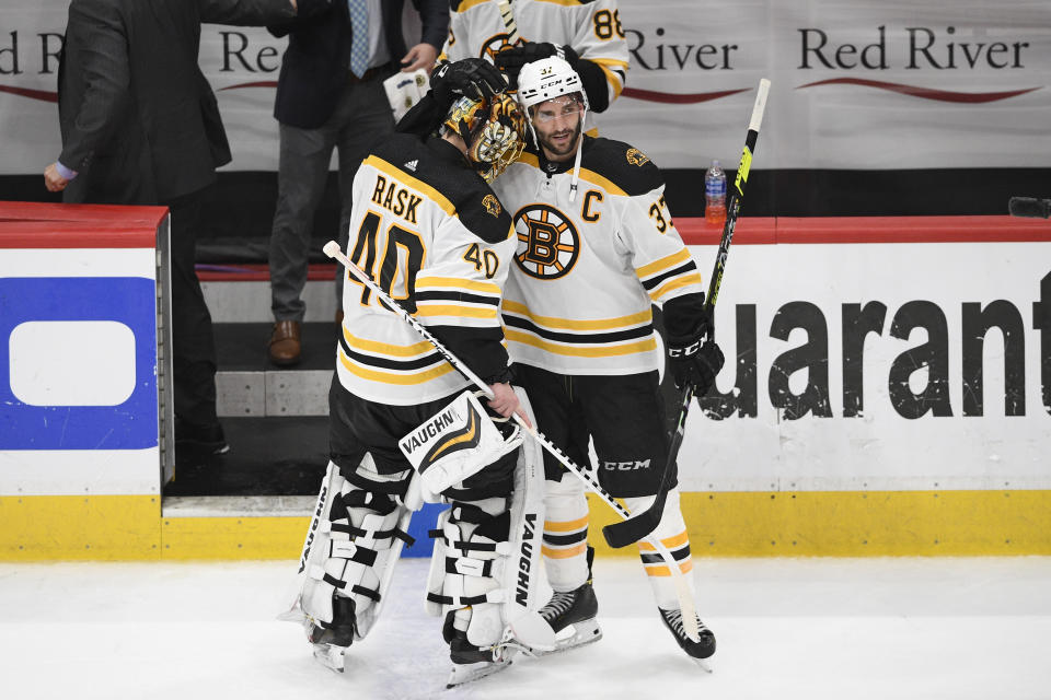 Boston Bruins center Patrice Bergeron (37) and goaltender Tuukka Rask (40) react as they leave the ice after Game 5 of an NHL hockey Stanley Cup first-round playoff series against the Washington Capitals, Sunday, May 23, 2021, in Washington. The Bruins won 3-1. (AP Photo/Nick Wass)