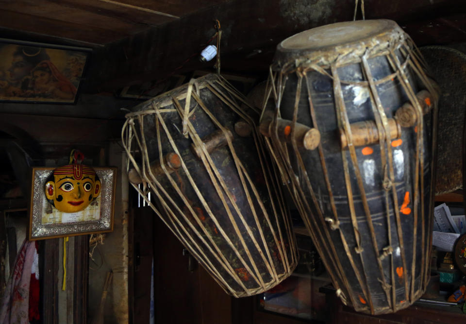 In this Oct. 16, 2018, photo, masks and drums used for dances in Indra Jatra Festival are hung in a room at Bhaktapur, Nepal. For centuries, Nepal has celebrated the Indra Jatra festival of masked dancers, which officially begins the month-long festivities in the Hindu-dominated Himalyan nation. The dancers, who come from a variety of backgrounds, pull off this performance every year despite minimal financial support from the government and other sources, they say. (AP Photo/Niranjan Shrestha)