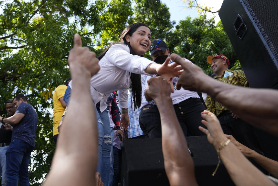 Aurora Silva greets supporters after she was named the new Democratic Unity Roundtable gubernatorial candidate for Barinas State, during a demonstration in support of her husband, opposition leader Freddy Superlano, in Barinas, Venezuela, Saturday, Dec. 4, 2021. Superlano, who was leading the race for governor in Barinas State in the recent Nov. 21 regional elections, called for a protest this Saturday after a court ruling ordered new elections in the state and disqualified him from running. (AP Photo/Ariana Cubillos)