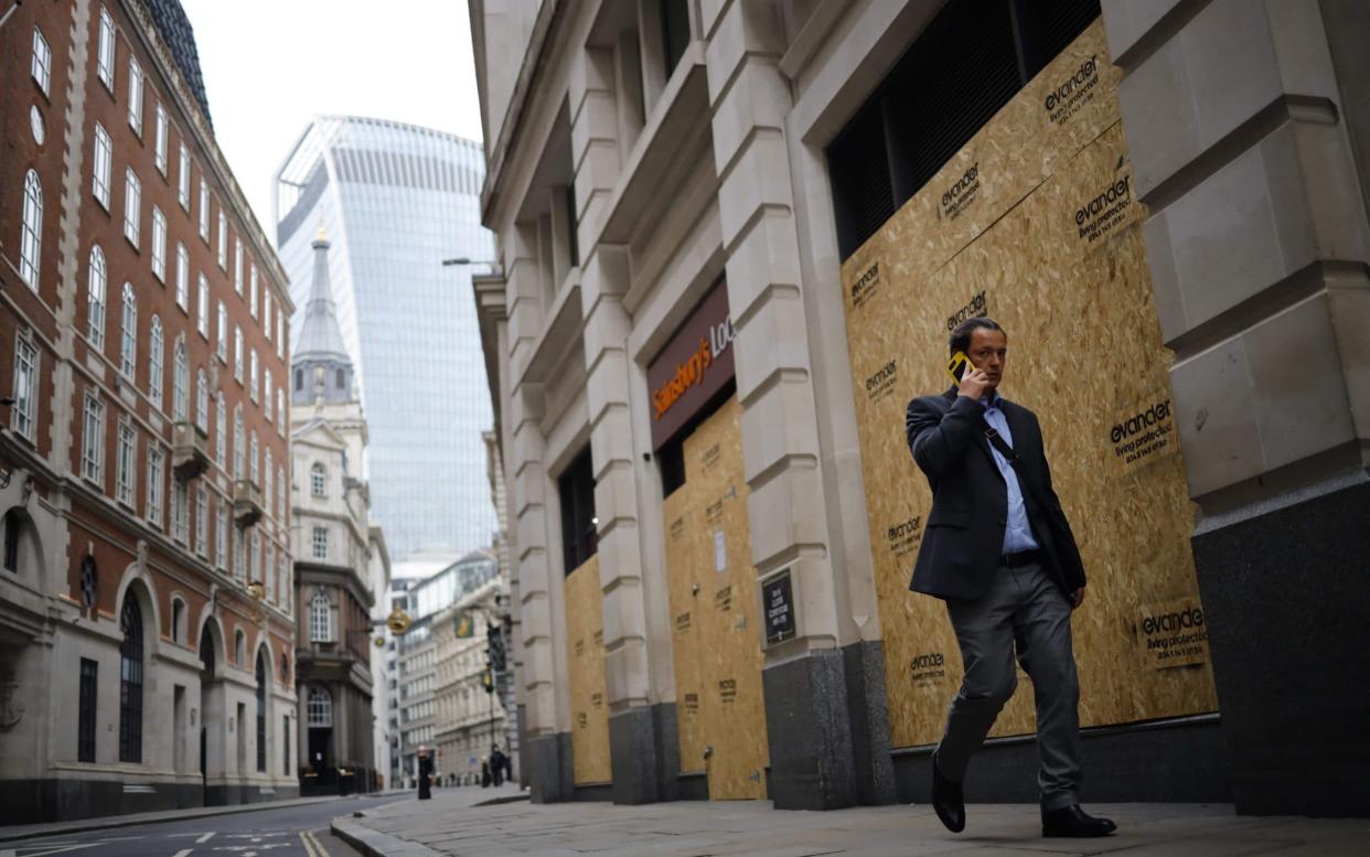 A worker walks through an all but deserted City of London during the first lockdown. Last year, Boris Johnson was at pains to encourage people back to the office amid dire predictions about the cost of them staying away - Tolga Akmen/AFP