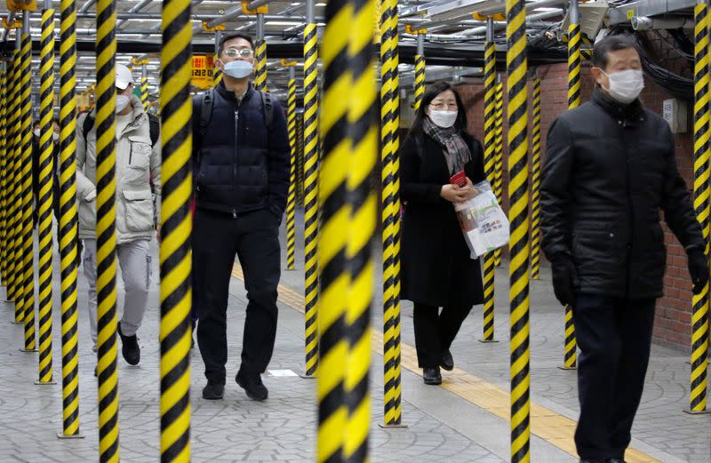 Personas con máscaras como medida preventiva contra el coronavirus caminan en una estación de metro en Seúl