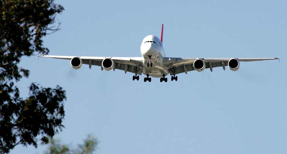 An aircraft is shown landing. Wild weather on Australia's east coast has forced airlines to cancel flights.