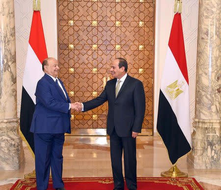 Egypt's President Abdel Fattah al-Sisi (R) shake hands with his Yemeni counterpart Abd-Rabbu Mansour Hadi (R) at the presidential palace in Cairo , Egypt, August 13, 2018 in this handout picture courtesy of the Egyptian Presidency. The Egyptian Presidency/Handout via REUTERS