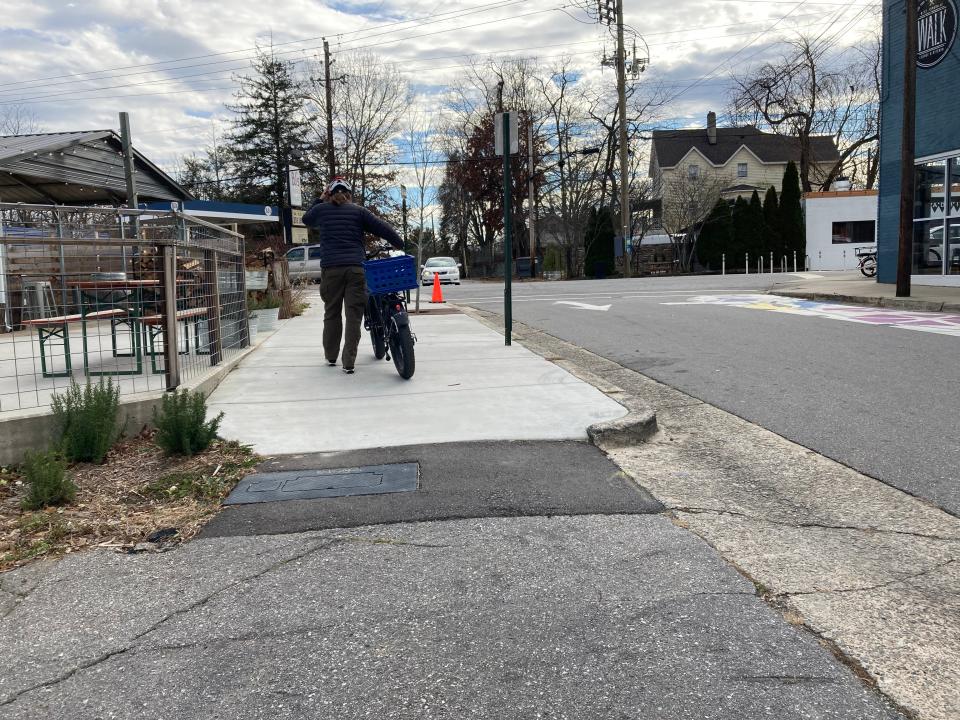 Part of its proposed resurfacing project, the NCDOT invites public input on improvements for Haywood Road. On Dec. 2, 2022, a cyclists pushes their bike up Michigan Avenue, toward Haywood Road.