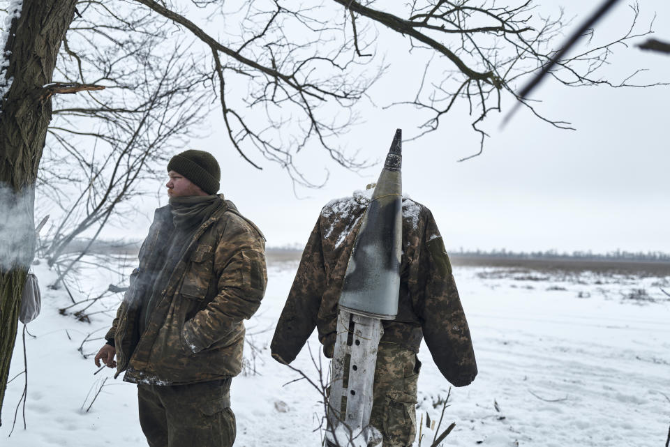 A Ukrainian soldier stands near an effigy on the frontline, Donetsk region, Ukraine, Saturday, Feb. 18, 2023. (AP Photo/Libkos)