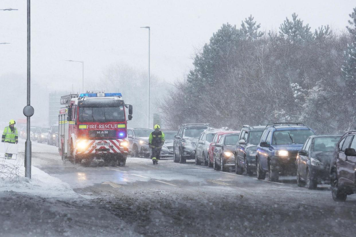 A fire engine passes motorists queuing on a road off the A30 near Okehampton in Devon: PA