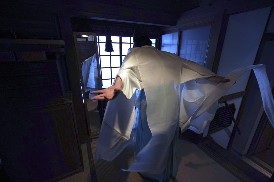 In this May 8, 2020, photo, Ryoki Ono, head priest, wears a ritual dress prior to performing a livestream prayer during a 10-day trial of "online shrine" visit program at Onoterusaki Shrine in downtown Tokyo, allowing its visitors to join rituals from their homes. The shrine also accepted from worshipers their prayer messages, which were printed on a virtual wooden tablet each and offered to the Shinto gods to keep away evil spirits and the epidemic. (AP Photo/Eugene Hoshiko)