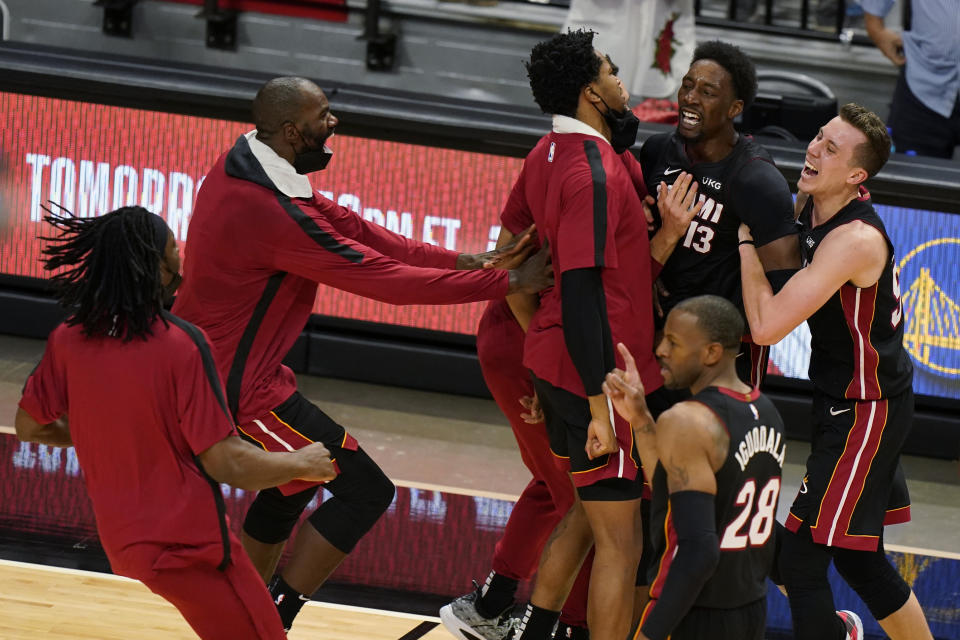 Miami Heat center Bam Adebayo (13) is mobbed by teammates after he made the winning shot against the Brooklyn Nets at the end of an NBA basketball game, Sunday, April 18, 2021, in Miami. (AP Photo/Wilfredo Lee)