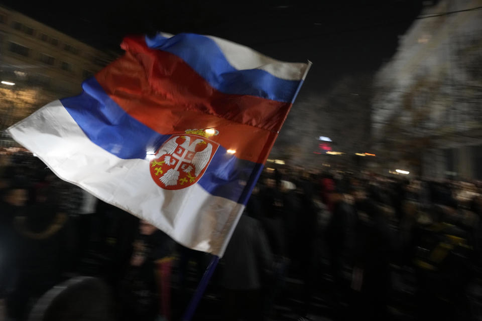 FILE - A man waves a Serbian, bottom, and Russian flags during a protest against the Serbian authorities and French-German plan for the resolution of the Kosovo, in Belgrade, Serbia, Wednesday, Feb. 15, 2023. The leaders of Serbia and Kosovo are holding talks Monday on European Union proposals aimed at ending a long series of political crises and setting the two on the path to better relations and ultimately mutual recognition. (AP Photo/Darko Vojinovic File)