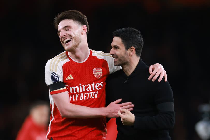 Arsenal midfielder Declan Rice embracing manager Mikel Arteta