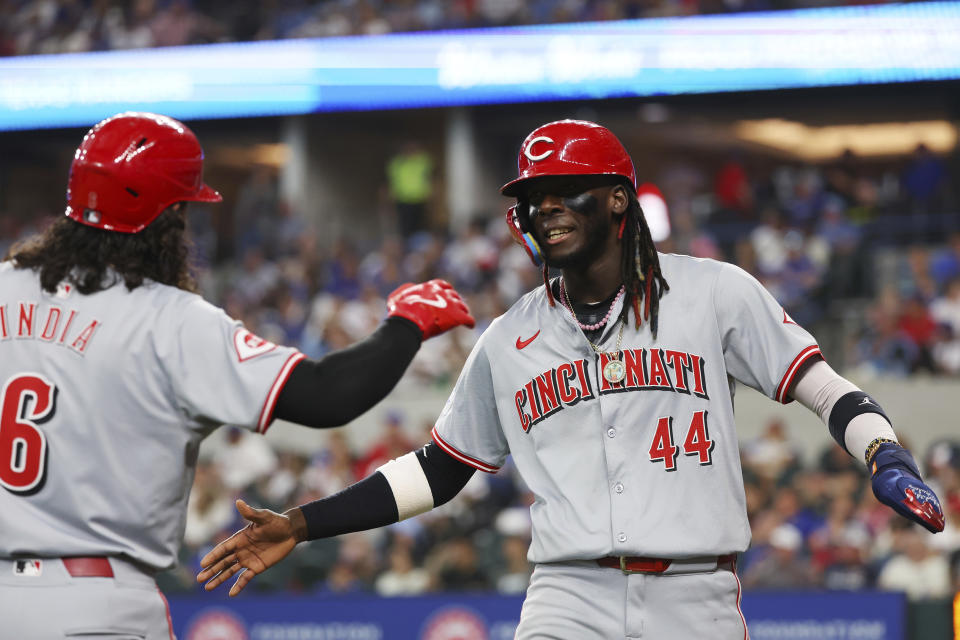 Cincinnati Reds' Jonathan India (6) greets Elly De La Cruz (44) after De La Cruze scored against the Texas Rangers in the sixth inning of a baseball game Sunday, April 28, 2024, in Arlington, Texas. (AP Photo/Richard W. Rodriguez)