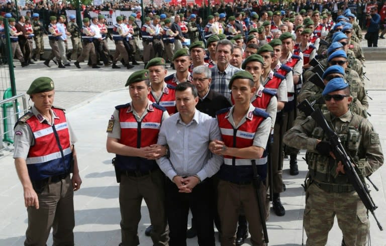 The suspects in the trial over the attempted coup in Turkey last year are paraded into the courtroom by heavily armed security forces