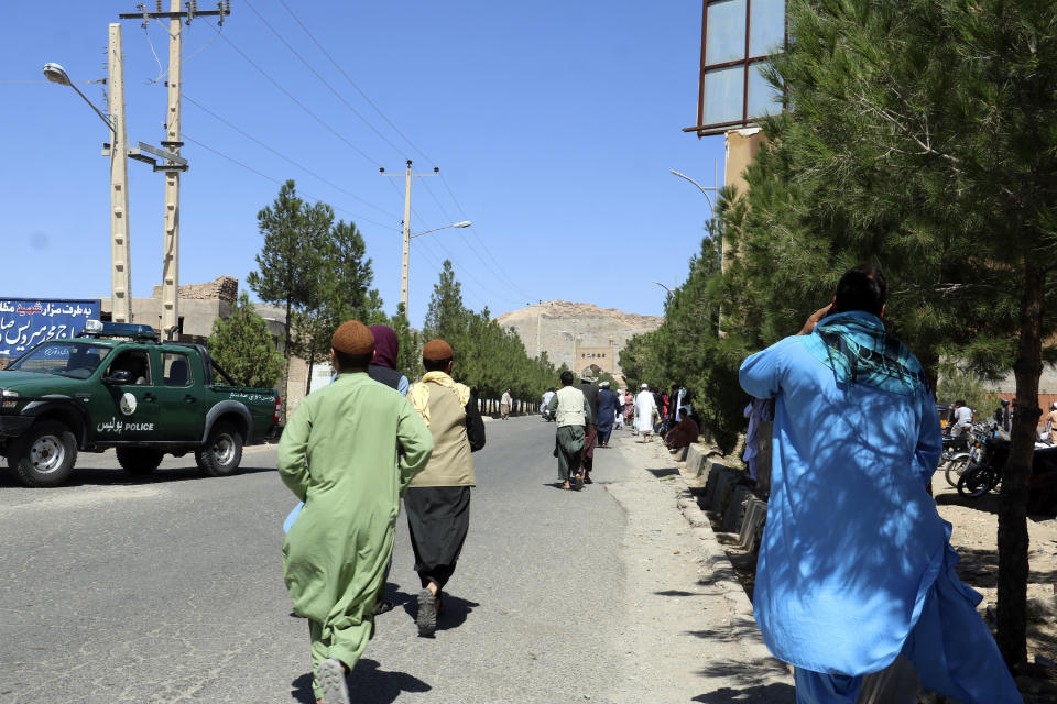 Afghan people run near the site of an explosion in Herat province, Afghanistan, Friday, Sept 2, 2022. Taliban officials and a local medic say an explosion tore through a crowded mosque in western Afghanistan, killing more than a dozen of people, including a prominent cleric. (AP Photo/Omid Haqjoo)