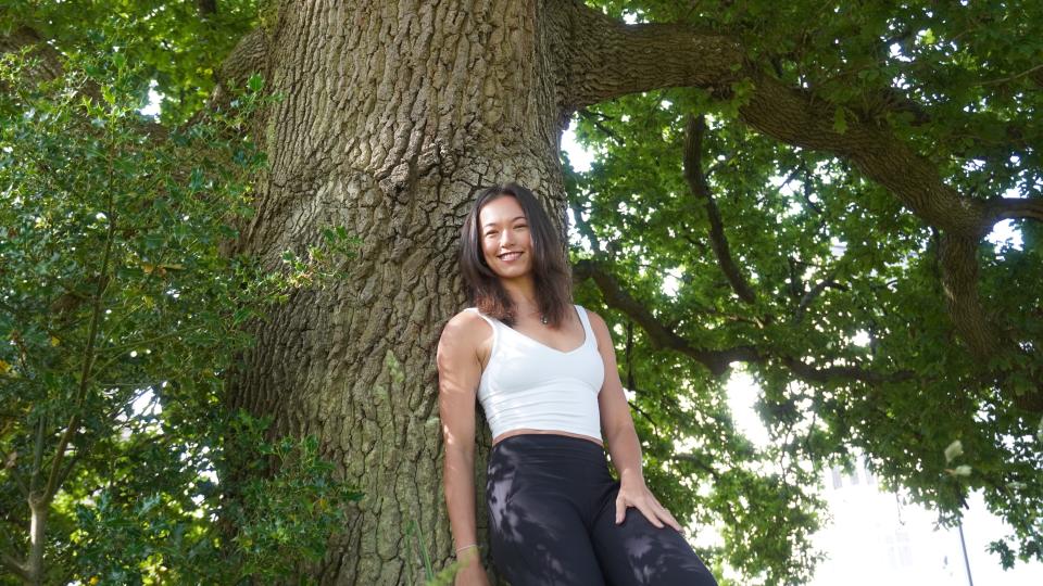 lady leaning against the tree trunk