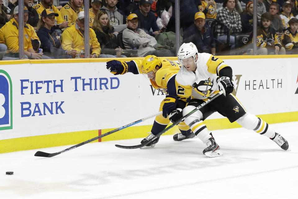 Pittsburgh Penguins defenseman Chad Ruhwedel (2) and Nashville Predators right wing Craig Smith (15) skate into the corner after the puck during the second period of an NHL hockey game Friday, Dec. 27, 2019, in Nashville, Tenn. (AP Photo/Mark Humphrey)