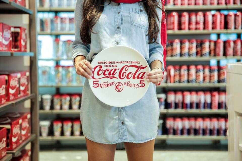Woman holding plate in Coca-Cola store