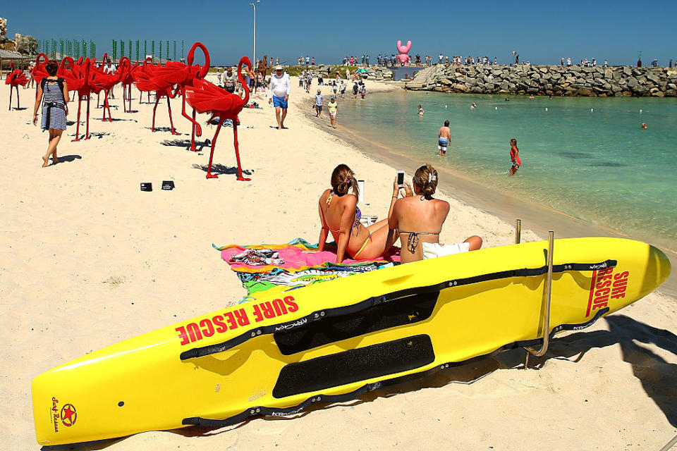 Pictured is two women sunbathing at Perth's Cottesloe beach.