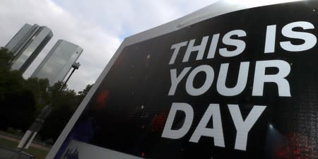 FILE PHOTO: A placard reading "This is your day" is seen on a lamp post next to the head quarter of Germany's largest business bank, Deutsche Bank in Frankfurt