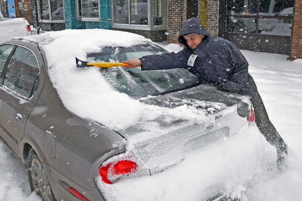 Ayden Ereth brushes snow from his vehicle in downtown Bismarck, N.D., on Tuesday, Feb. 21, 2023. A monster winter storm took aim at the Upper Midwest on Tuesday, threatening to bring blizzard conditions, bitterly cold temperatures, and 2 feet of snow in a three-day onslaught that could affect more than 40 million Americans.