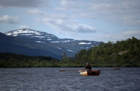 Kathryn Bennett, a postgraduate student in earth science at the University of New Hampshire, rows across a lake at a research post at Stordalen Mire near Abisko