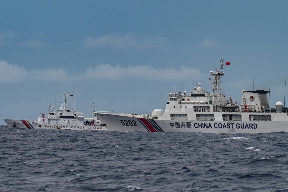 Isang barko ng China Coast Guard (R) ang naglayag sa isang Philippine Coast Guard (L) sa isang supply mission sa Sabina Shoal sa pinagtatalunang karagatan ng South China Sea noong Agosto 26, 2024.