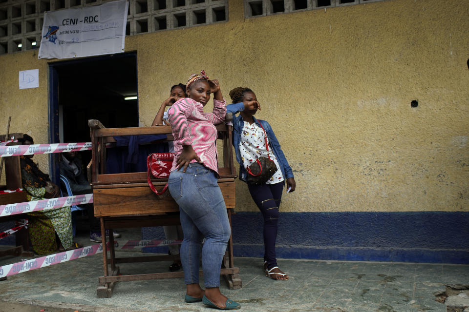 Congolese voters wait at the St. Raphael school in the Limete district of Kinshasa Sunday, Dec. 30, 2018, for voter's listings that have not arrived. People had started to gather at 6am to cast their votes, and four hours later, vote had not started as the lists were not available. Forty million voters are registered for a presidential race plagued by years of delay and persistent rumors of lack of preparation. (AP Photo/Jerome Delay)